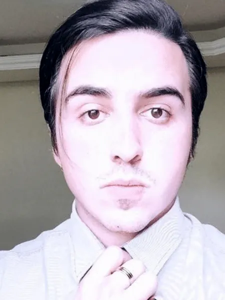 Gabriel de Xangô, de camisa clara, olhando para a câmera
